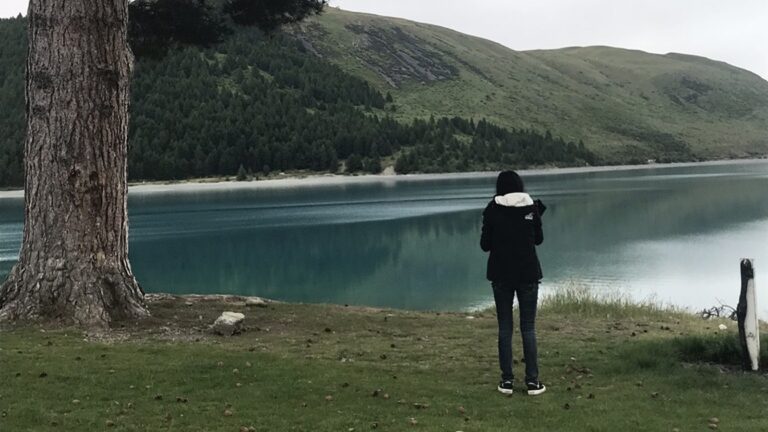 Woman standing by a lake in New Zealand